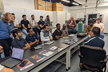 a group of scientists sit at a table