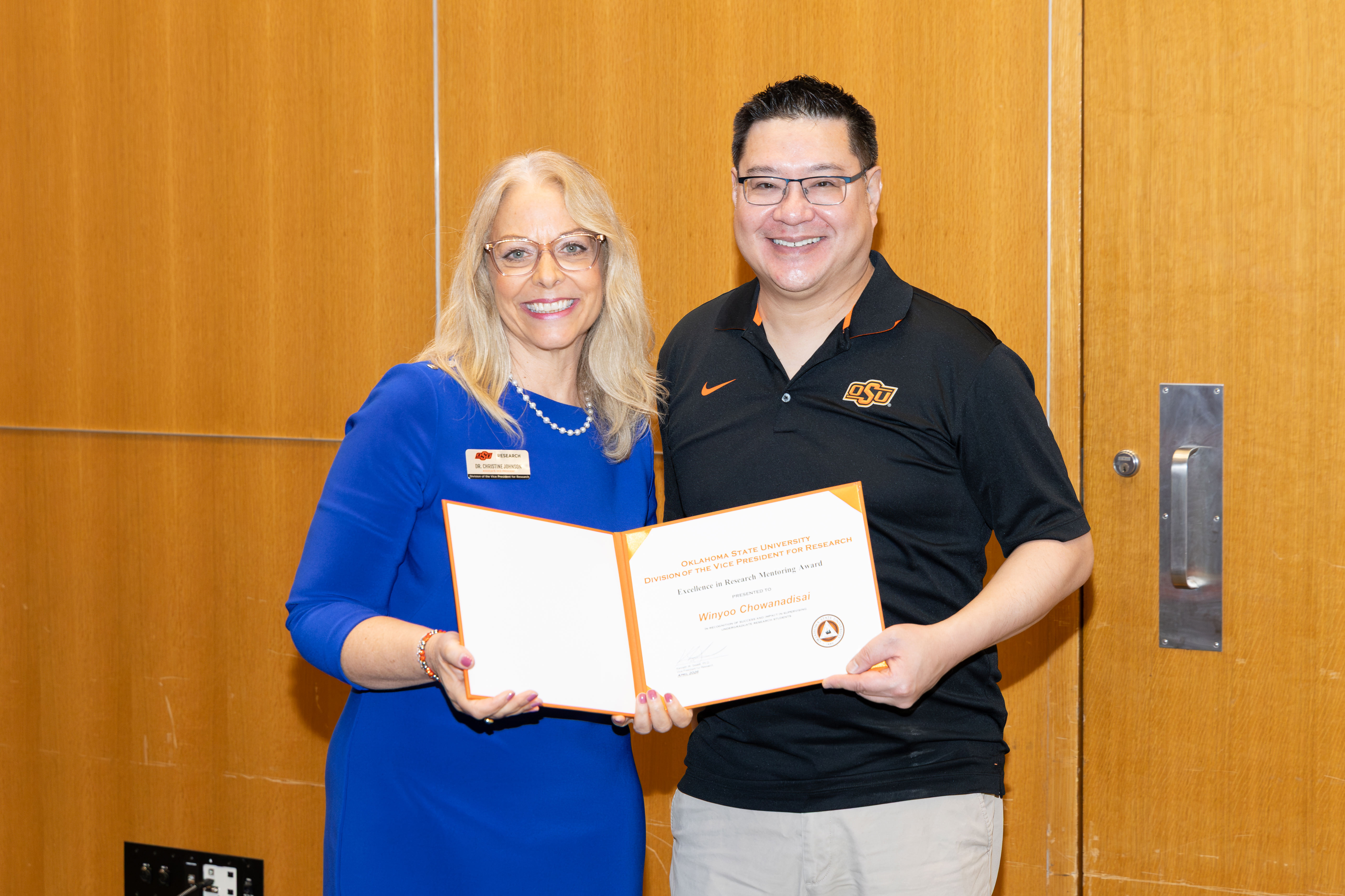 a man and a woman hold a certificate