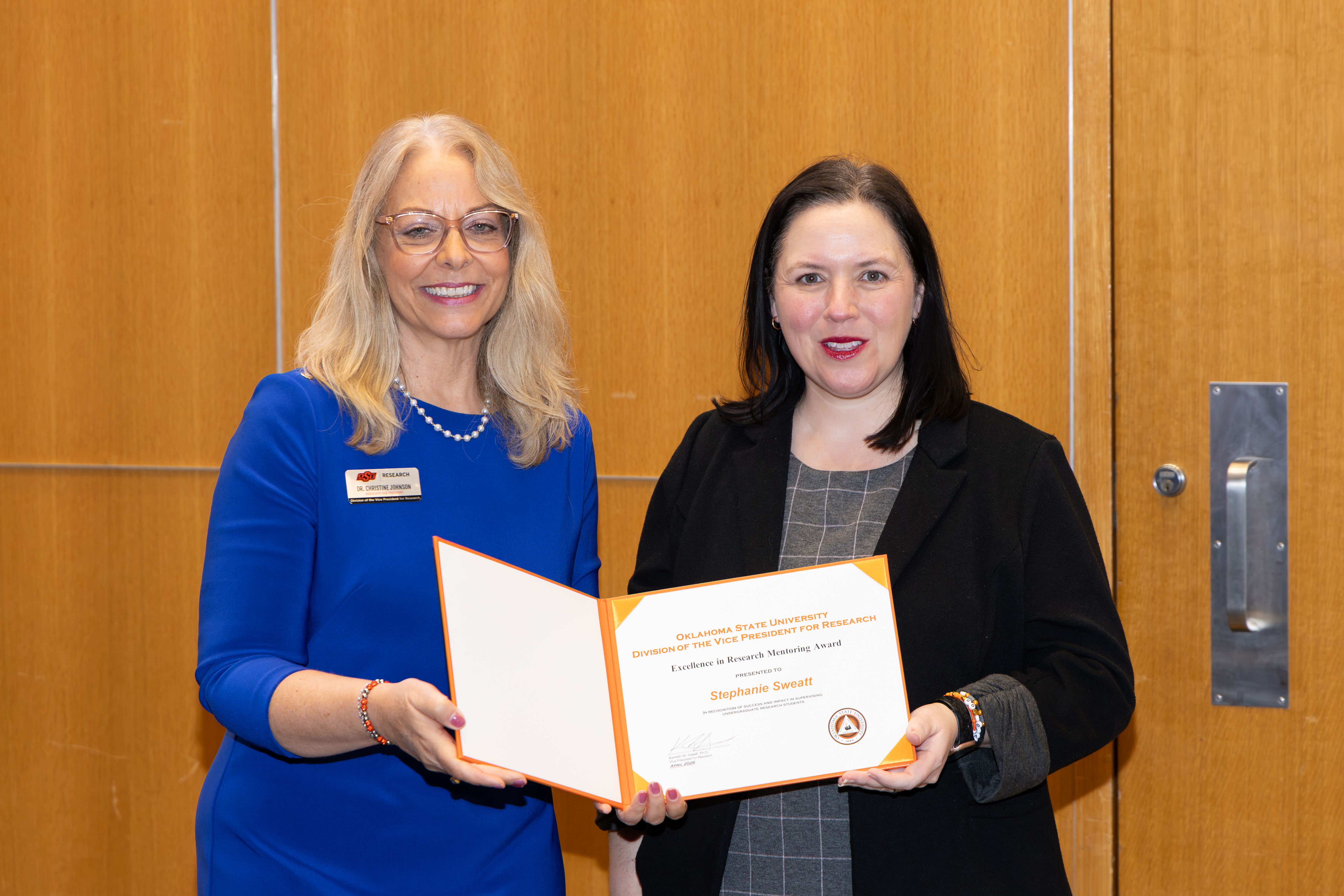 two women hold a certificate