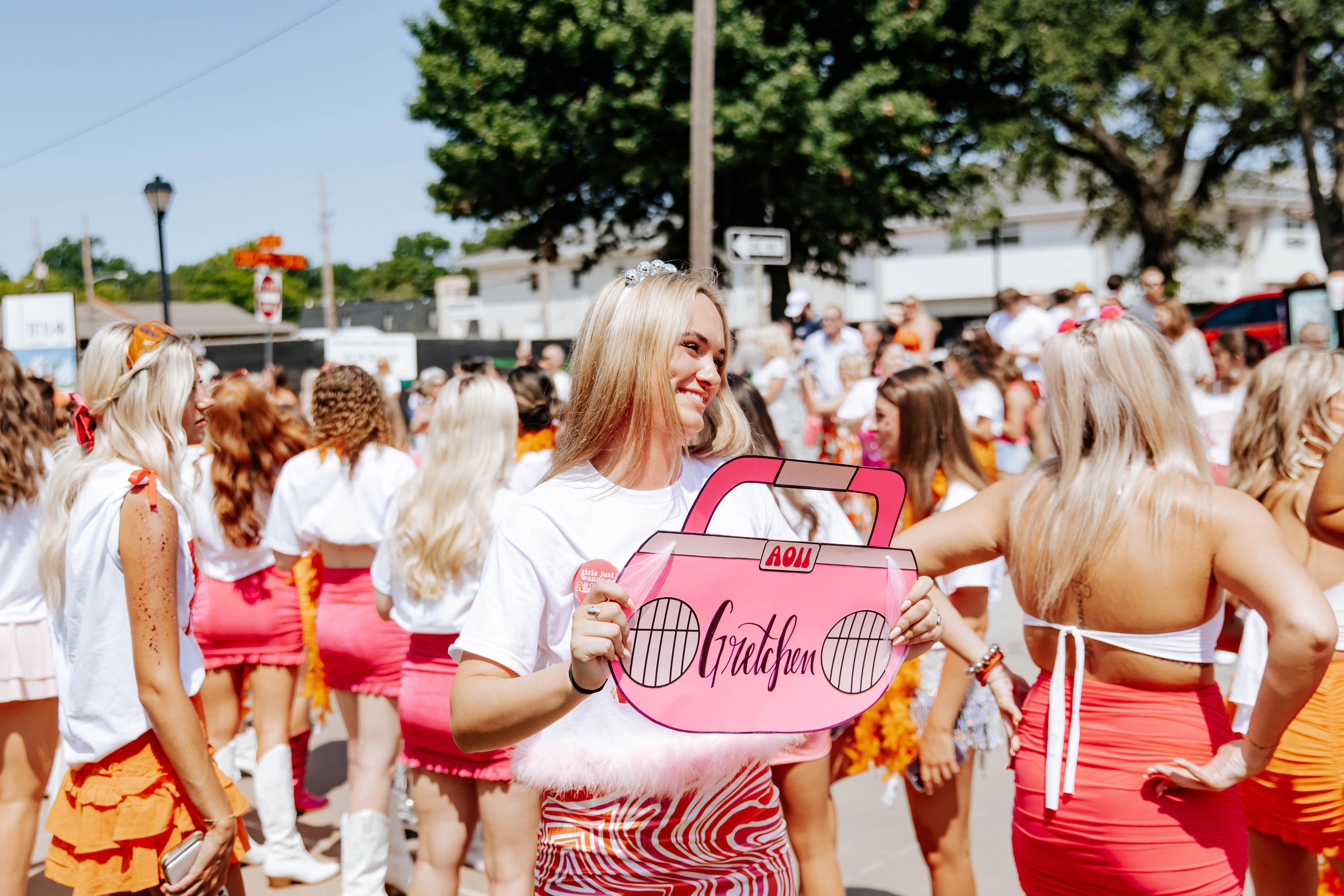 AOII member waits for Gretchen to run home with a sign that says Gretchen 