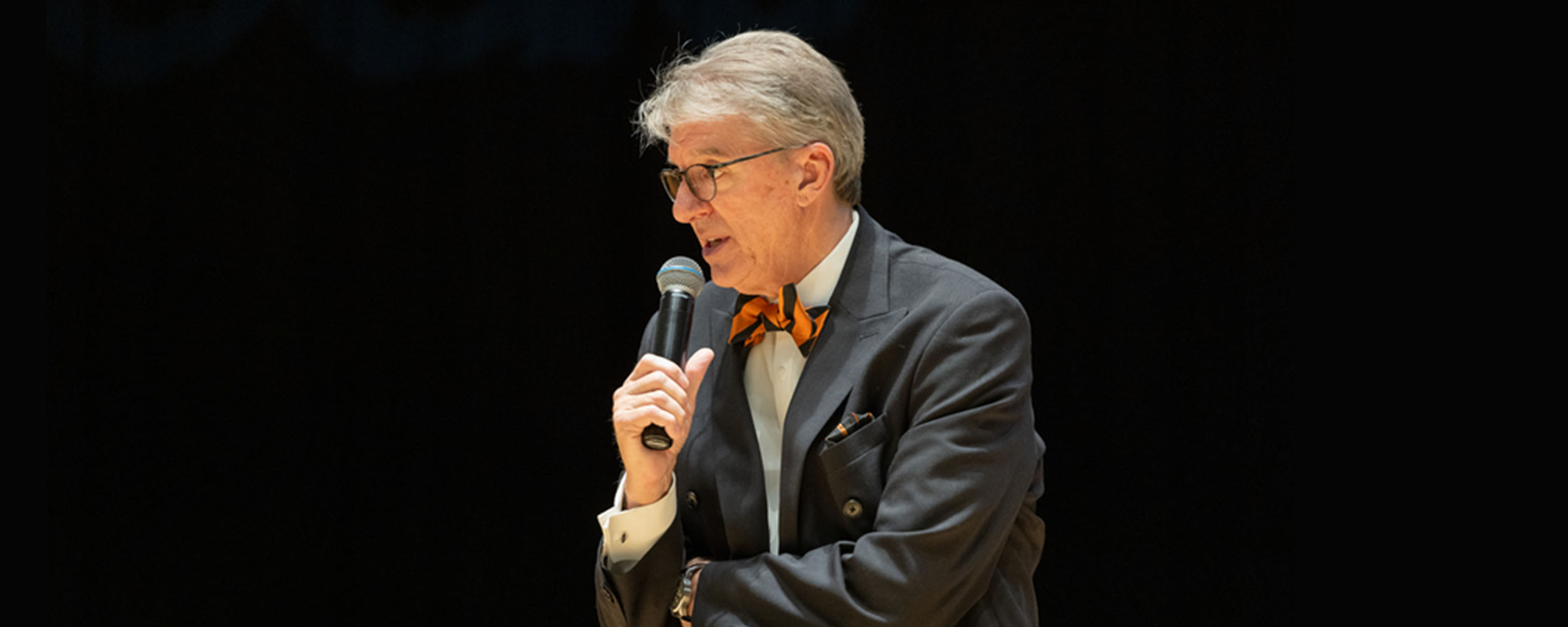 President Jim Hess of Oklahoma State University standing on stage speaking into a microphone, delivering his “Legacy Talk” as Lead Week comes to an end.