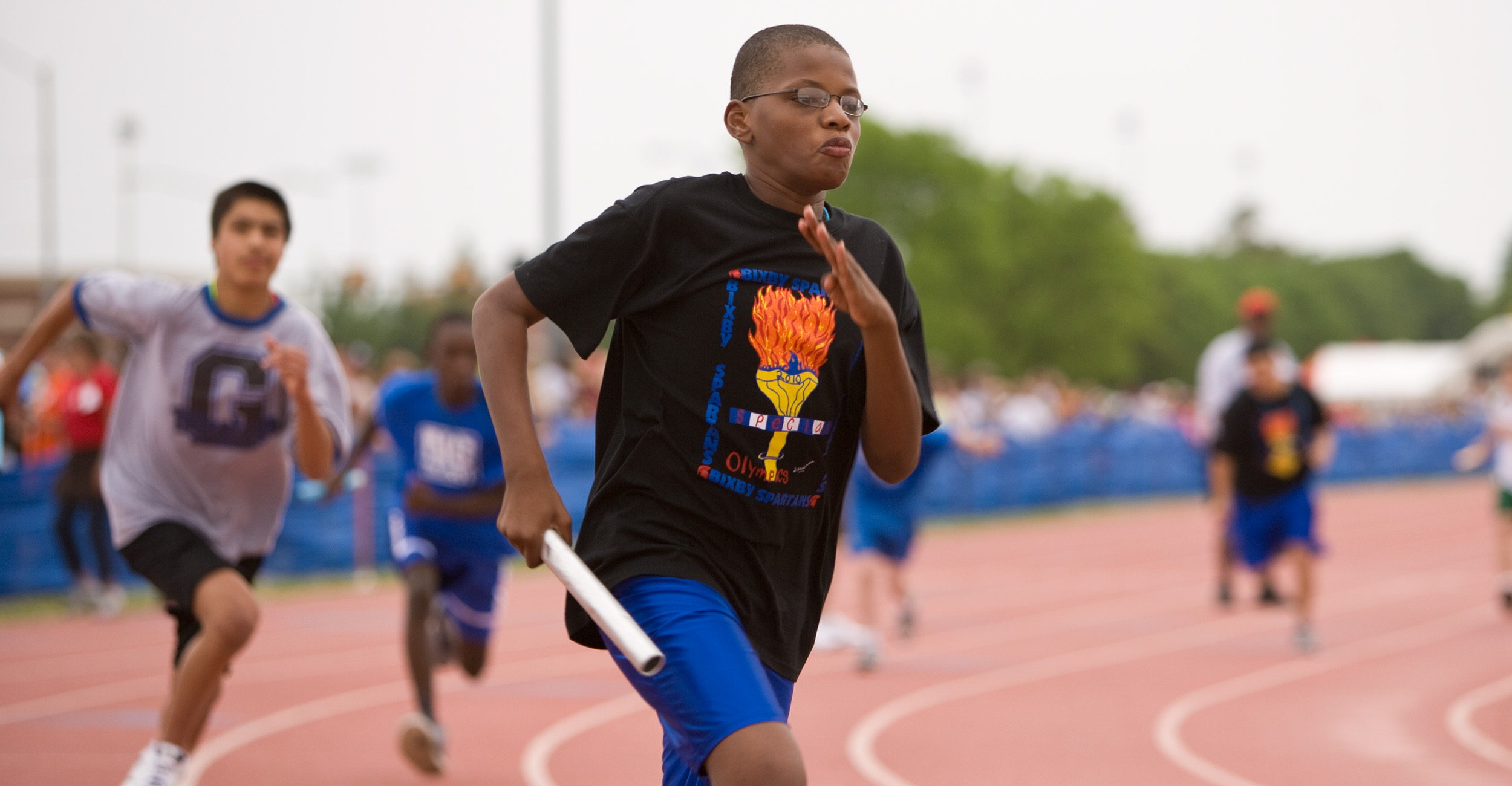 A special olympics athlete rounds the track at OSU running the relay race.