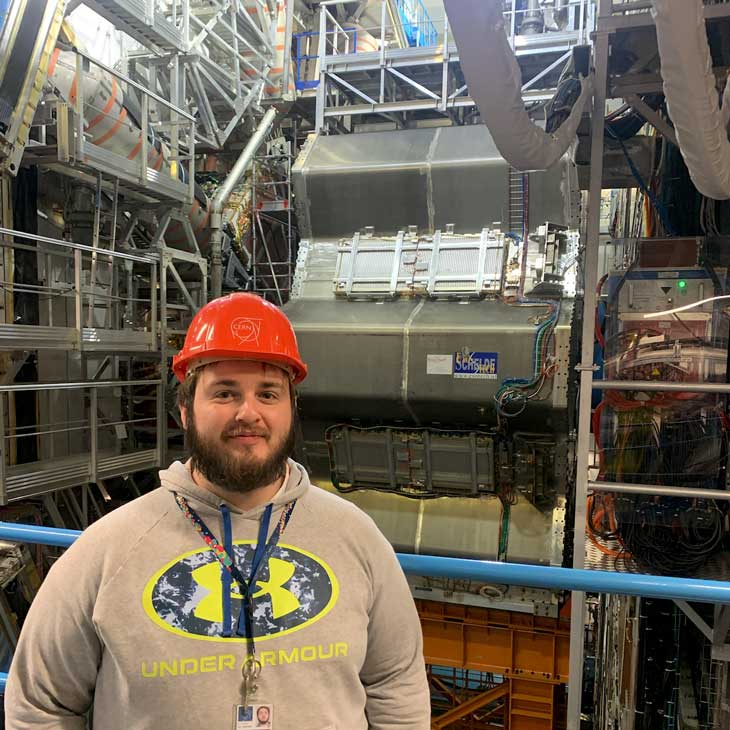 zack stands infront of the ATLAS detector