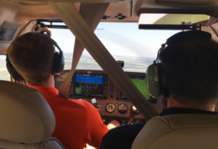 Two pilots flying a plane looking for drones