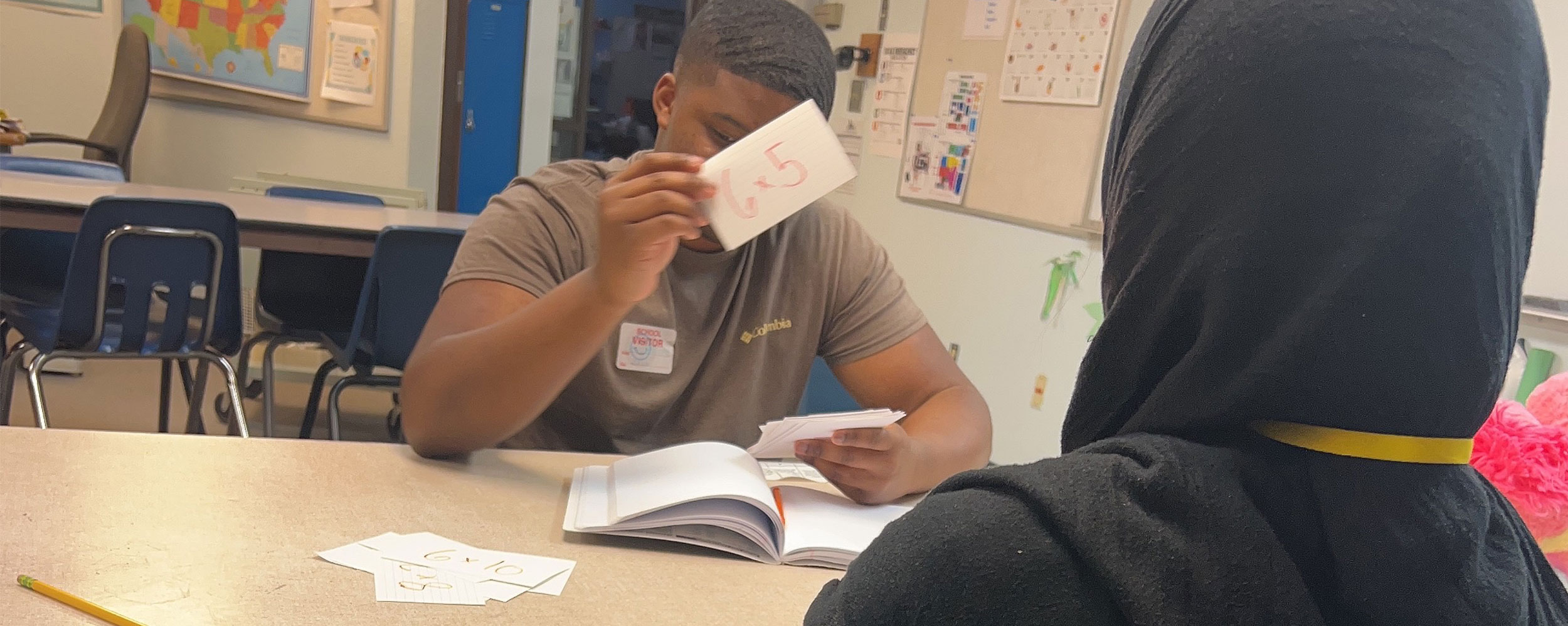 Tutor working with student in classroom.