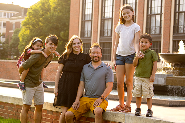 Family gathered around fountain in front of Edmon Low Library