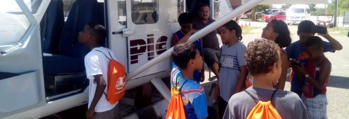 Students in Belize looking at a plane