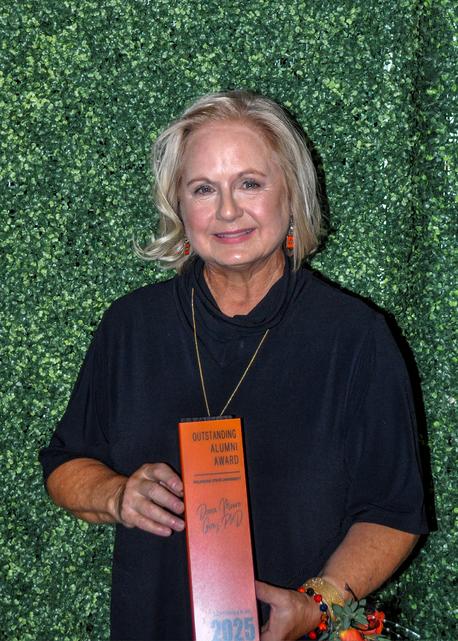 Dr. Dana Moore Gray holding Outstanding Alumni award