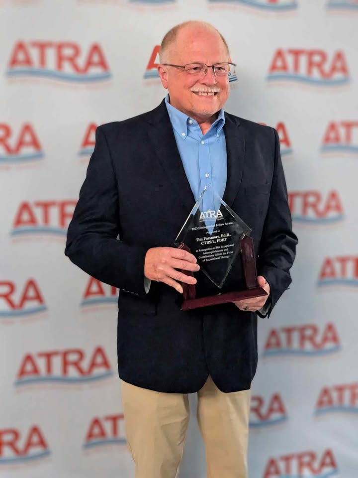Dr. Tim Passmore holding Distinguished Fellow award