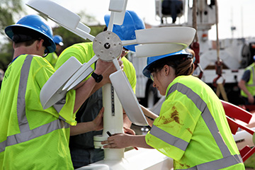 Senior design students installing the Wind Turbine Light Sculpture