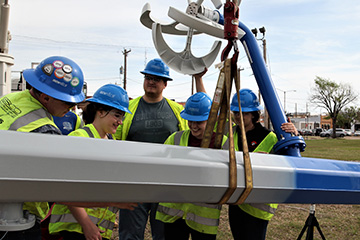 Senior Design Students install the Wind Turbine Sculpture Light Feature on Block 34