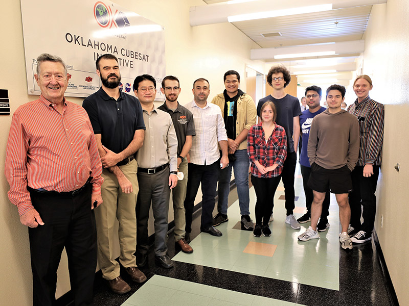 Jack Graham and ECE professors and students stand outside the CubeSat Lab