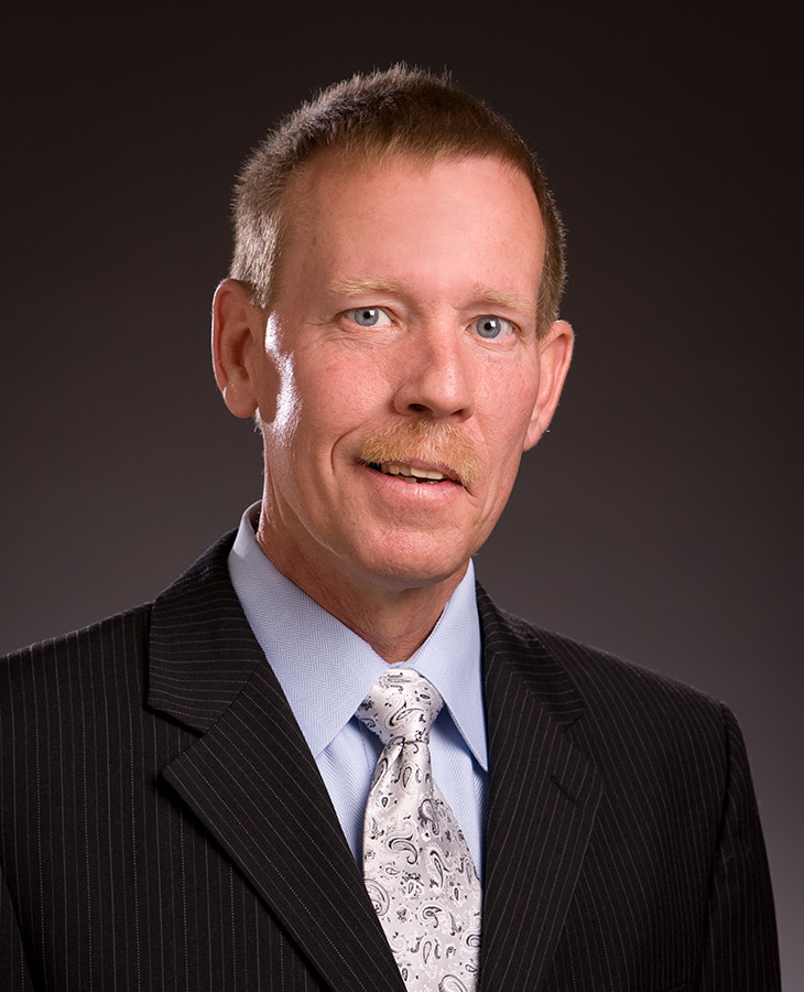 A man in a suit with a mustache and tie, exuding professionalism and style.