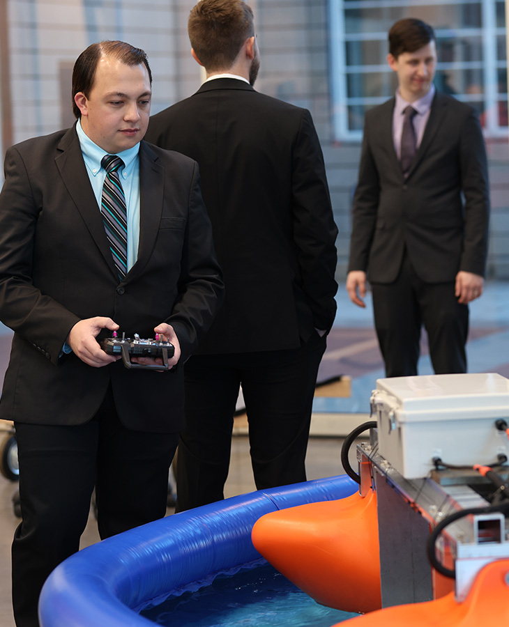 A man in a suit confidently holds a remote control, poised and ready to engage with the device.