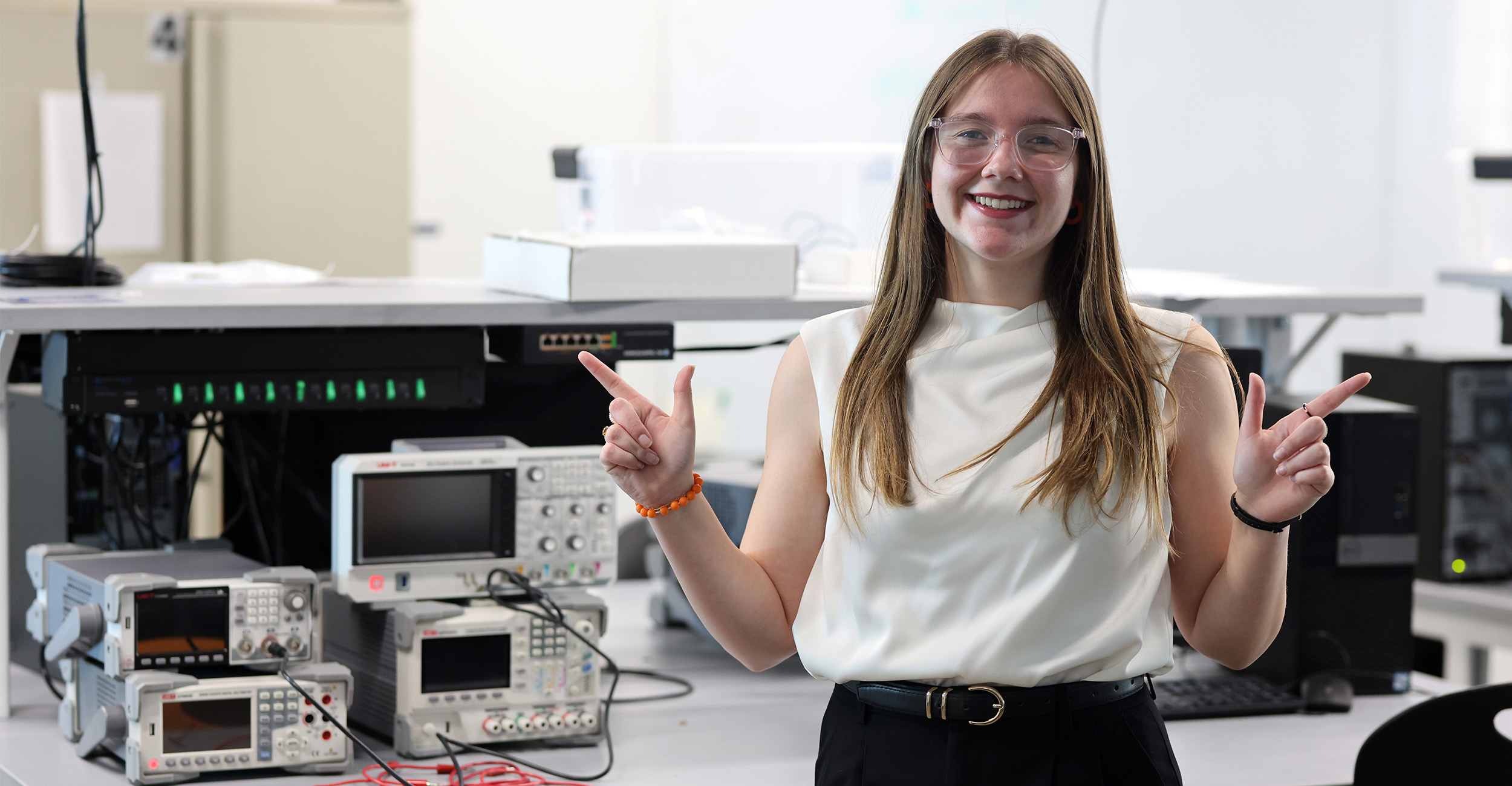 Abigail McCrary stands in a computer lab surrounded by equipment used in her work as an electrical and computer engineering student. She is photographed in a lab in ENDEAVOR on the Oklahoma State University campus.