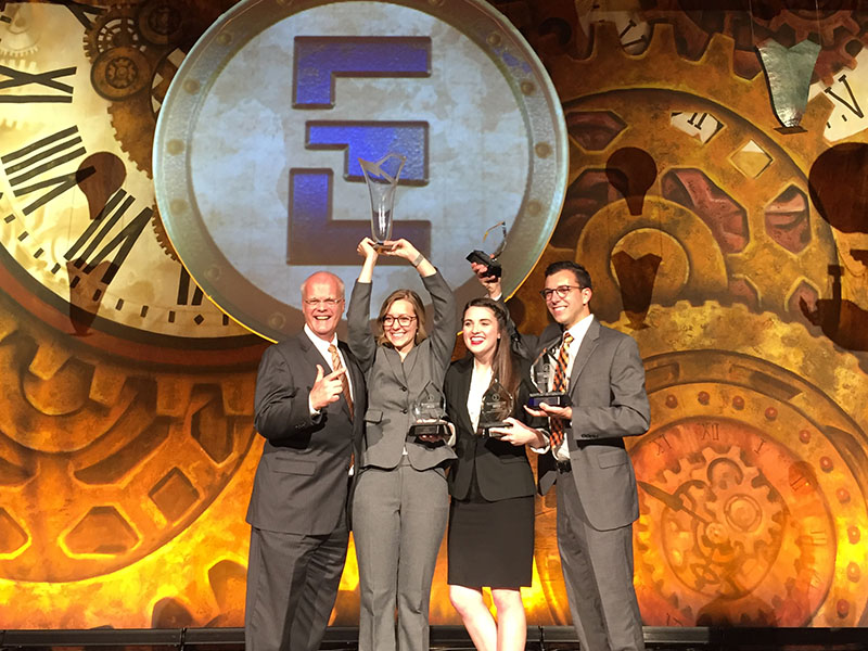 Individuals standing on stage receiving awards.
