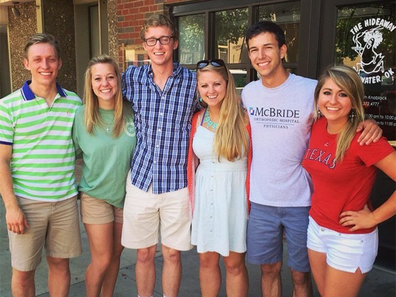 A group of college students standing in front of Hideaway.