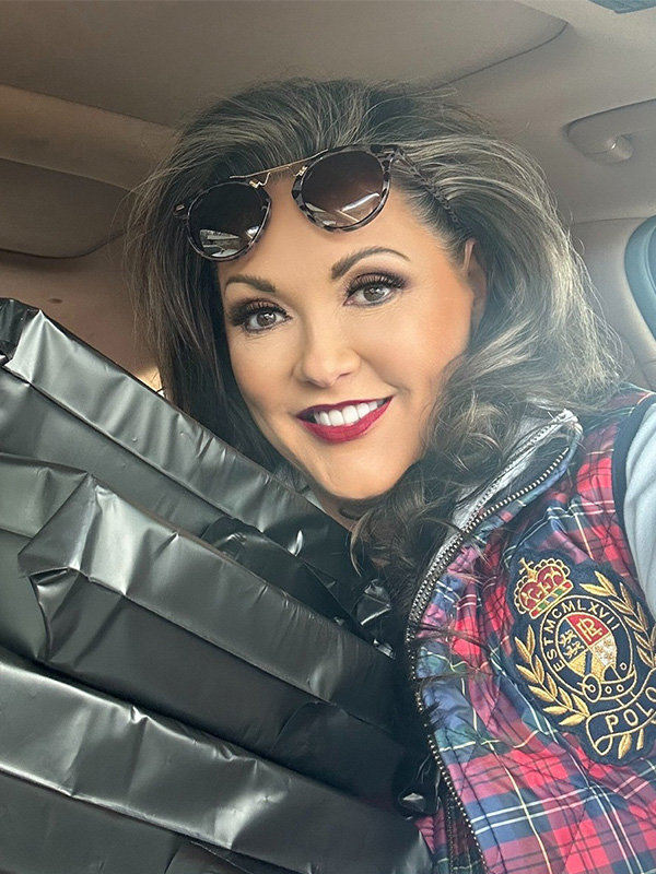 Paige Smith holding several N-Seam Saver's ready to be shipped out through the mail.