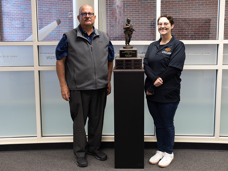 Associate Dean Ed Kirtley stands with Jenn Lane with refurbished trophy