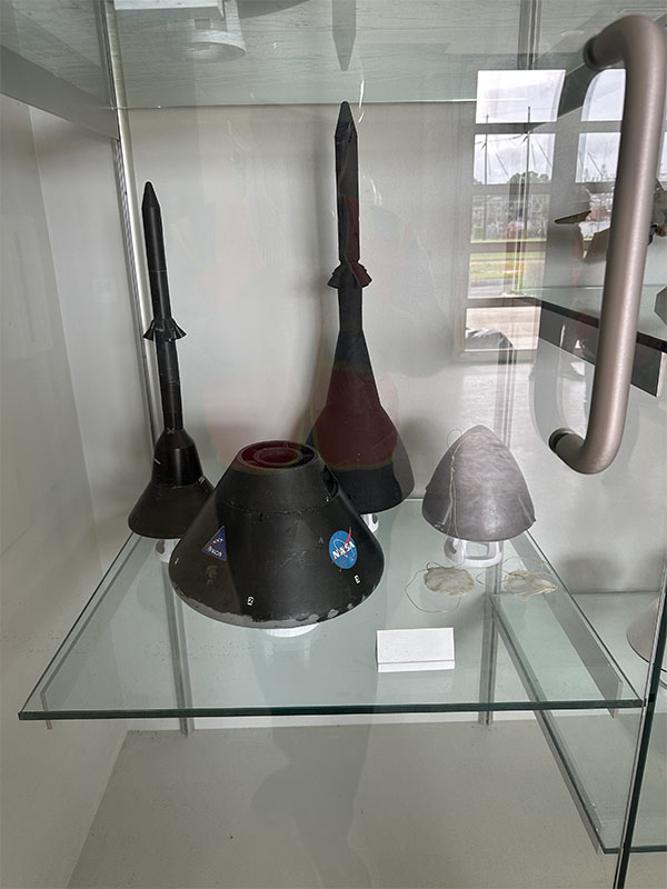 Spacecraft objects on display in a glass case from NASA.
