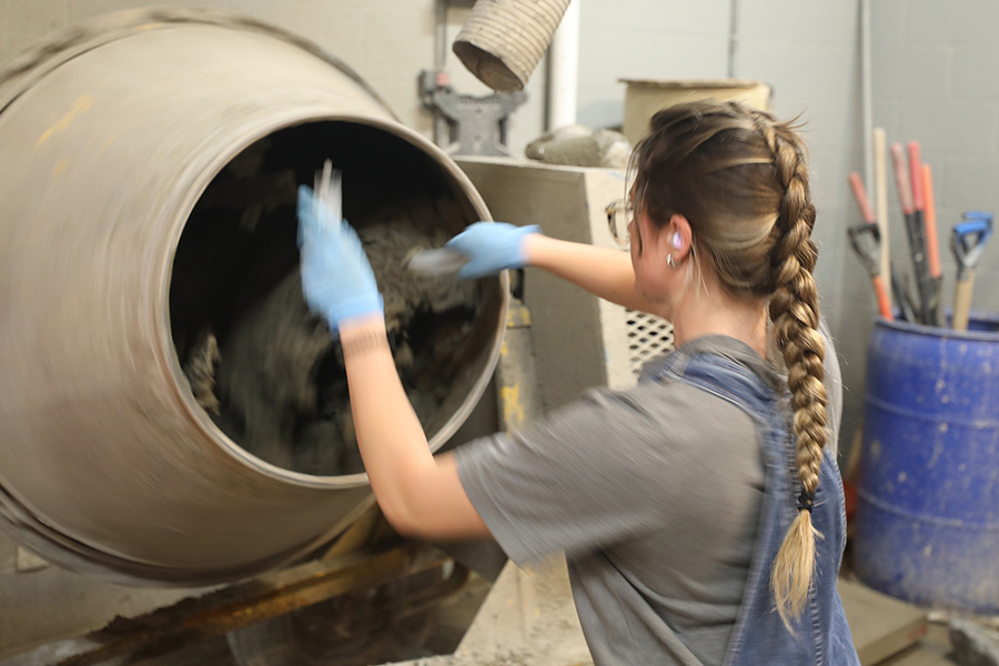 Containers of concrete mixtures are seen on a table in a laboratory setting.