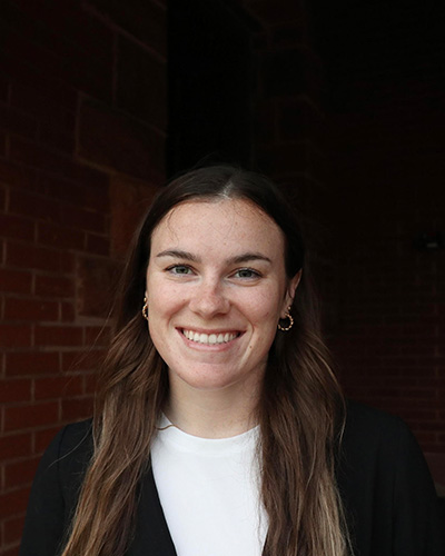 A woman wearing business clothing smiles for a portrait.