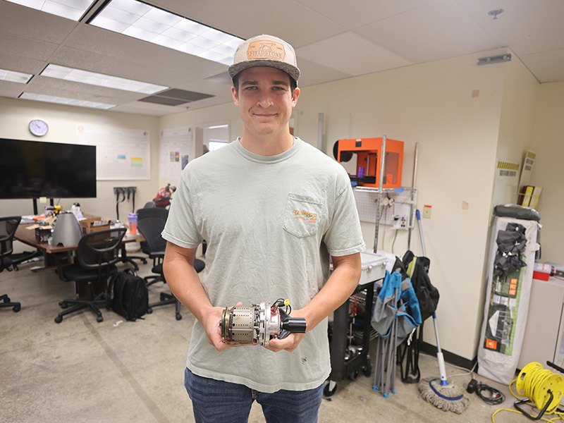 Zach Wattenbarger holds the internal components of an engine we designed and fabricated in-house with our combustor and parts scavenged from various other micro-turbojets engines.