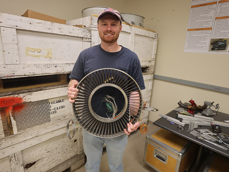 Bruce Lamoreaux holds an 18-in fan guide vanes from an Honeywell F109 engine