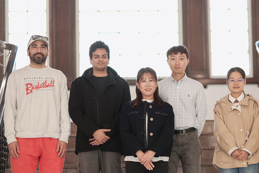 Dr. Ying Zhang stands with her studnents for a portrait photo.