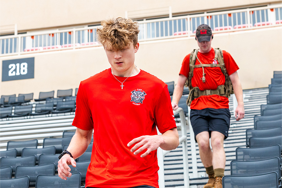 A photograph shows two people moving down rows of gray stadium seats.