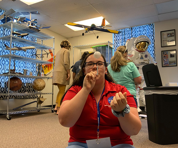 A woman takes part in an activity to show flight of a model airplane during NASA's STELLAR program geared toward teachers learning from NASA personnel to implement those lessons into their classroom curriculum. 