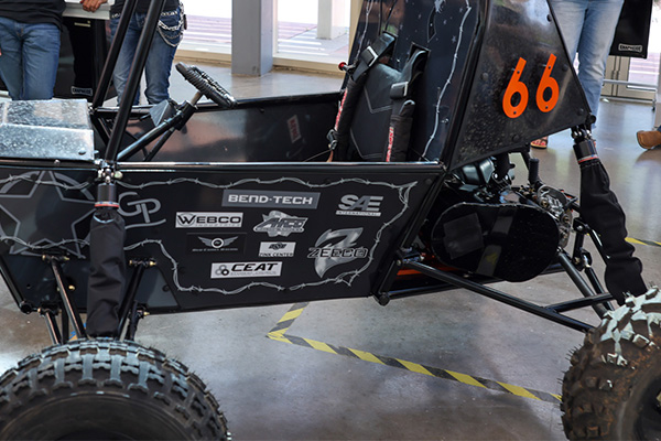 Close-up of a black off-road style student-built vehicle chassis with the number “66” and sponsor decals, highlighting engineering design details and construction.