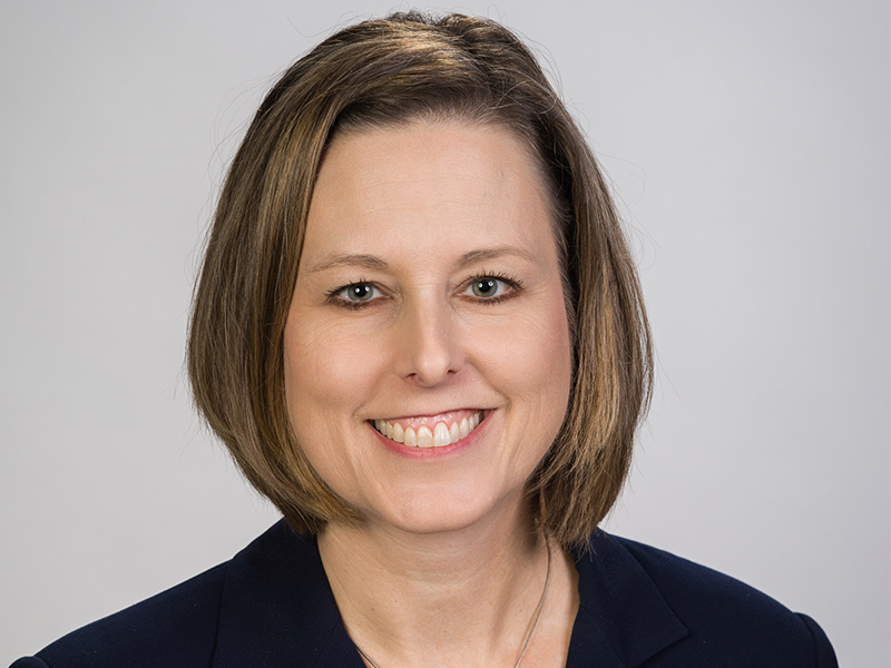 girl smiling for professional portrait wearing a dark blue blazer