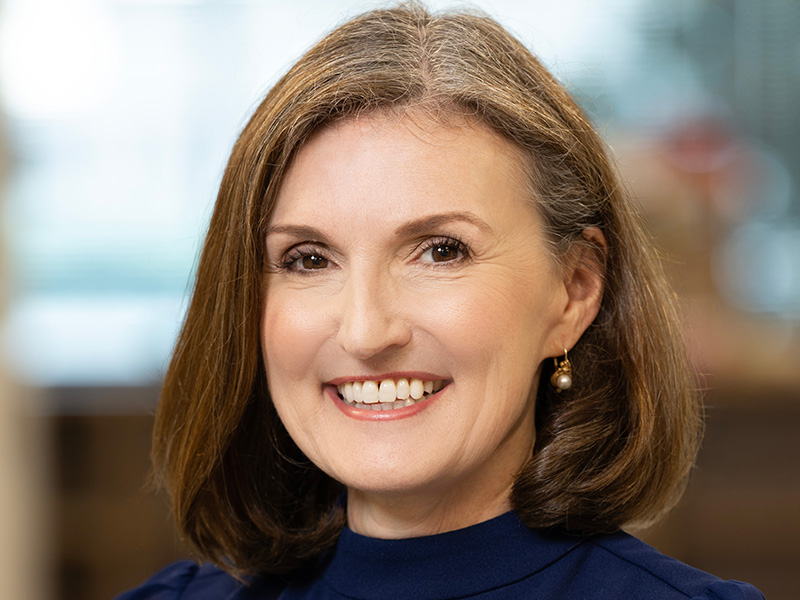 Girl smiling for a professional portrait wearing a blue shirt