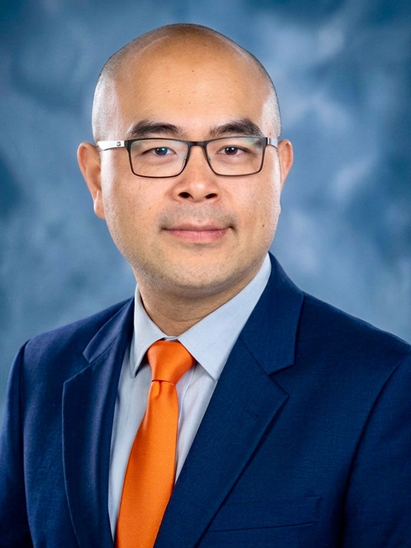 A man poses for a professional headshot.