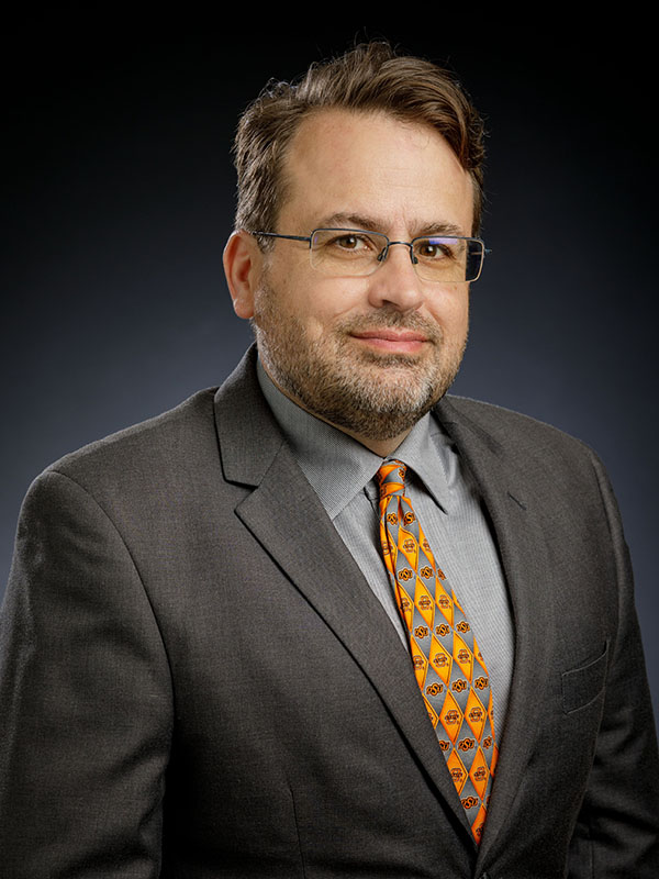 A man poses for a professional headshot.