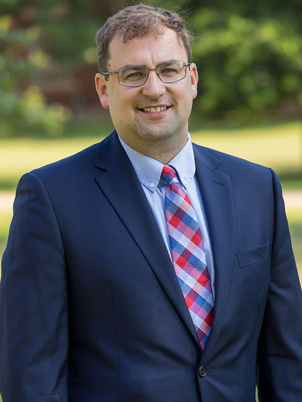 A man poses for a professional headshot.