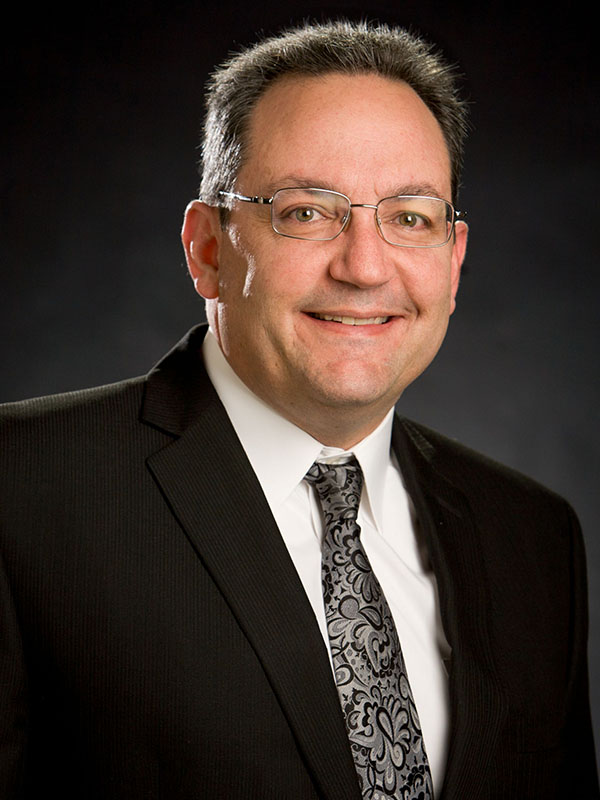 A man poses for a professional headshot.