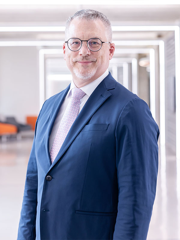 A man poses for a professional headshot.