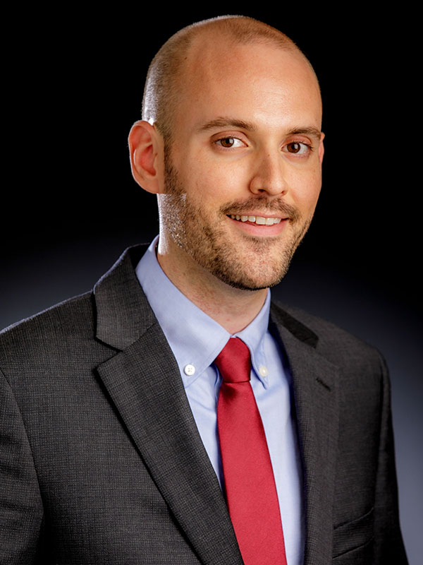 A man poses for a professional headshot.