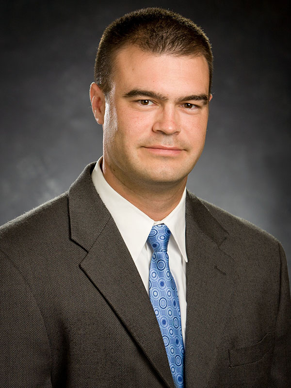 A man poses for a professional headshot.