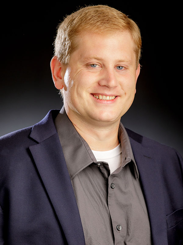 A man poses for a professional headshot.