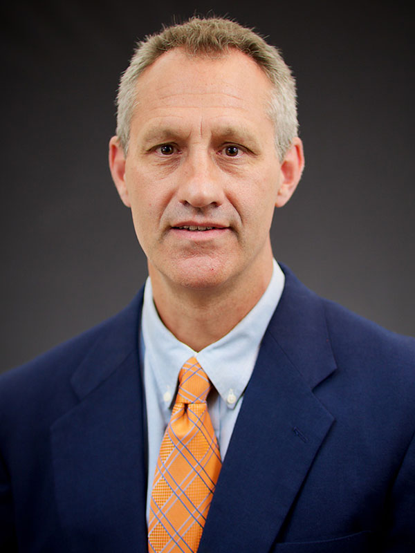 A man poses for a professional headshot.