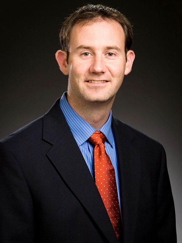 A man poses for a professional headshot.