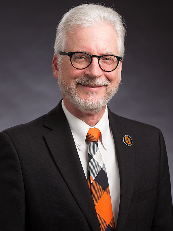 A man poses for a professional headshot.