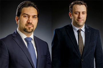 Two men in suits pose for portrait