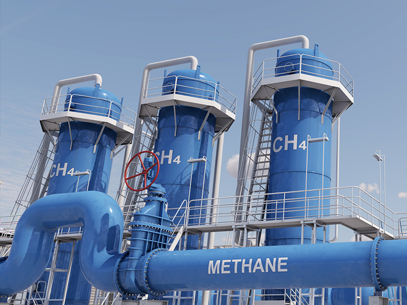 Blue methane storage tanks and connecting pipelines at an industrial energy facility, with methane chemical notation (CH4) visible on the tanks.