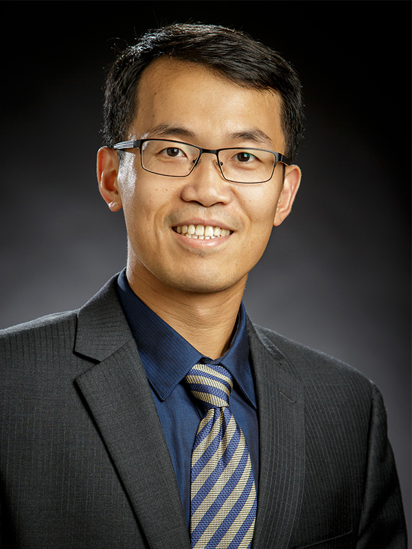 Headshot image of Dr. Yu Feng wearing a black button down shirt with a black and white tie