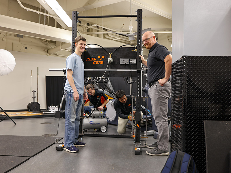 Four men work to put together REARGEAR 2.0, an innovative weightlifting concept developed through interdisciplinary research collaboration between three departments at OSU.