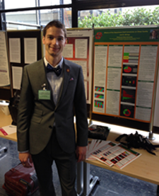 Joel Billings standing next to his award-winning poster display.